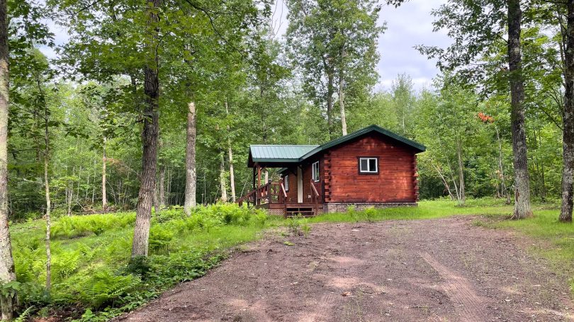 Outside image of rustic handcrafted cabin in the woods.