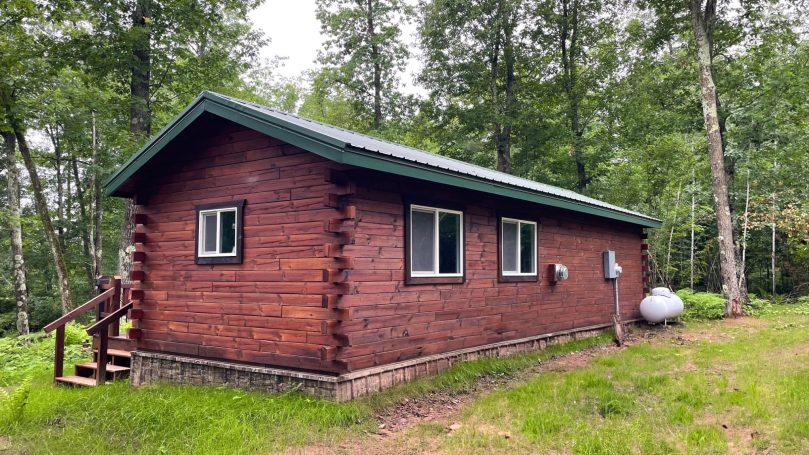 Back of rich dark finished log cabin built by the Amish.