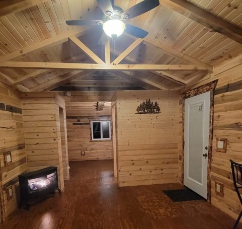 Beautiful wood interior of log cabin with wood stove.